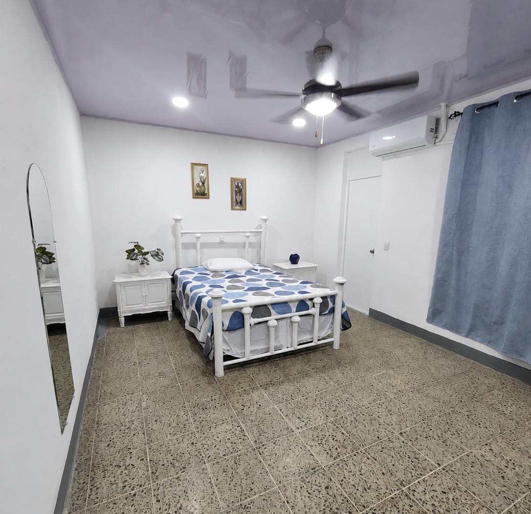 Habitación con cama matrimonial, aire acondicionado y ventilador de techo