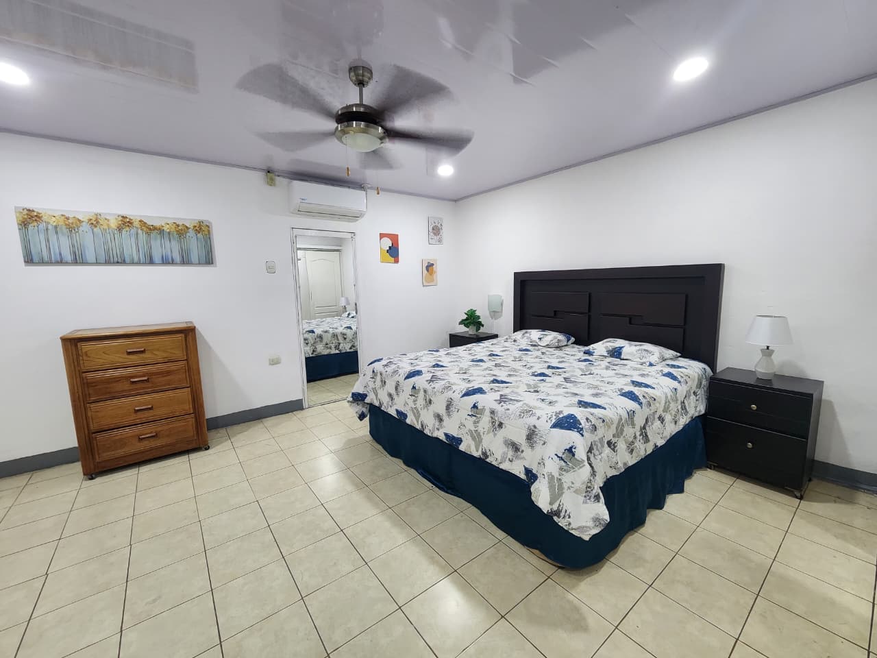 Vista amplia de la habitación con cómoda de madera y cortinas